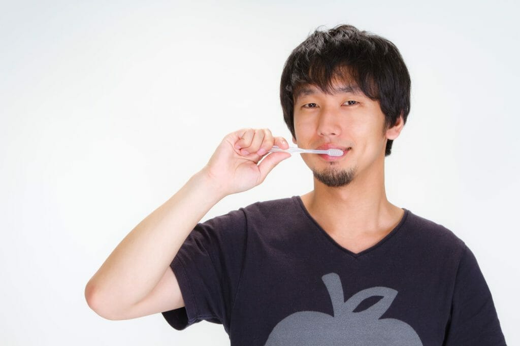 笑顔で歯磨きする男性