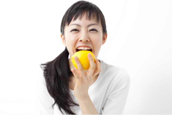 レモンをかじる女性
