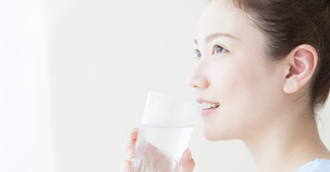 サプリ飲む女性