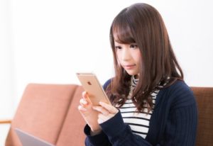 スマホで口コミをチェックする女性