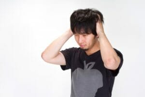 頭をかく男性