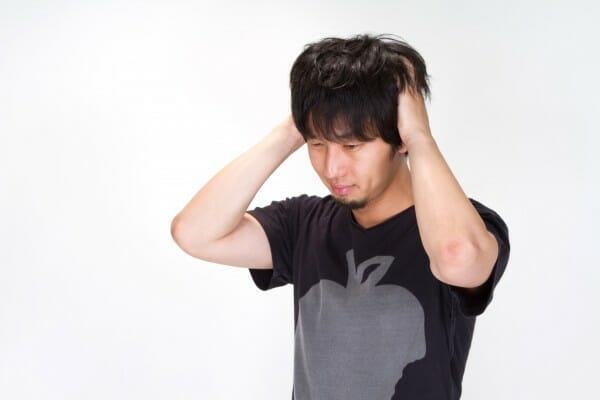 頭をかく男性