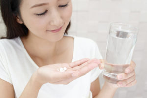サプリを飲む女性